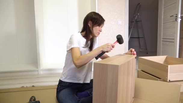 家具自组装过程中 采用橡胶锤锤击女性家具的细部 搬进新房 — 图库视频影像