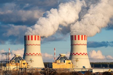 Nükleer enerji santralinin soğutucu kuleleri hava atmosferinde buhar emisyonları. Atom enerjisi üretimli sanayi bölgesi.
