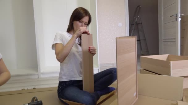 Kvinnan Läser Instruktioner För Att Montera Möbler Självmonterande Möbler Hemma — Stockvideo