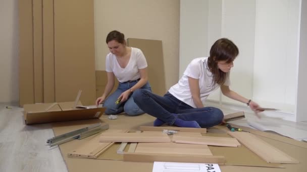 Kvinnor Flyttar Till Nya Hem Och Självmonterande Möbler Tillsammans Flyttar — Stockvideo