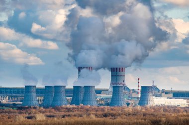 Atomik enerji santrali buharlı soğutma kulesi olan nükleer enerji santrali. Hava atmosferinde buhar salınımı olan nükleer sanayi bölgesi.