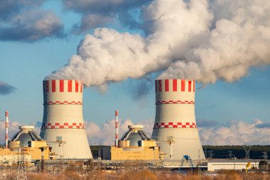 Atomik nükleer santralde buhar bulutları olan soğutma kulesi. Hava atmosferinde buhar salınımı olan nükleer sanayi bölgesi.