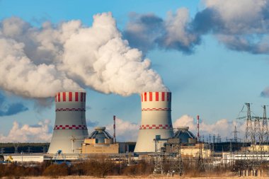 Nükleer enerji santralinin soğutucu kuleleri hava atmosferinde buhar emisyonları. Atom nükleer enerji üretimine sahip sanayi bölgesi