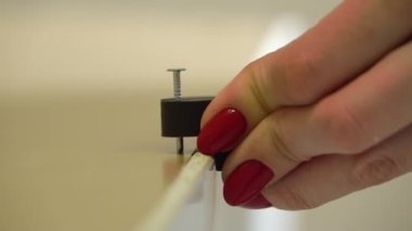 Kadın çekiç çekiçle çekiçle mobilyaları monte ederken çivi çakıyor. Yeni eve taşınıyorum..