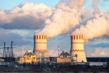 Nükleer enerji santrali ve atom nükleer santralinin soğutma kulesi. Hava atmosferinde buhar salınımı olan nükleer santrali olan sanayi bölgesi..