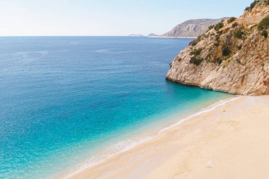 Kaputas plajı. Türkiye 'deki güzel turkuaz deniz ve kumlu plajda güneş ve denizin keyfini çıkaran insanlar