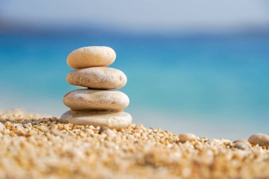 Piramit taşları kumsalın kumlarında dengelenir. Zen dengesi, minimalizm, uyum ve barış. Seçici odak