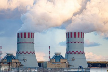 Atomik nükleer santralde buhar bulutları olan soğutma kulesi. Hava atmosferinde buhar salınımı olan nükleer sanayi bölgesi.