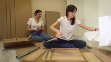 Mobilya montajı talimatlarını okuyan kadın