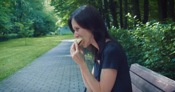 Mulher Comendo Fast Food Fora Parque Mordida Hambúrguer Parque Cidade — Vídeo de Stock