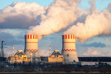 Nükleer enerji santralinin soğutucu kuleleri hava atmosferinde buhar emisyonları. Atom enerjisi üretimli sanayi bölgesi.