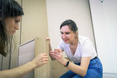 Evdeki mobilyaları monte eden yeni bir çift kadın.