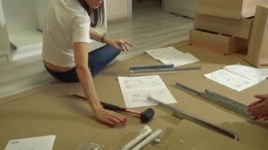 Milenyum kadınlarının oturma odasında mobilya montajı