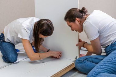 Evdeki mobilyaları monte eden yeni bir çift kadın.