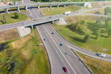 Hareket halindeki birkaç araçla banliyö kavşağının havadan görüntüsü. Banliyö karayolu altyapısı kavramı