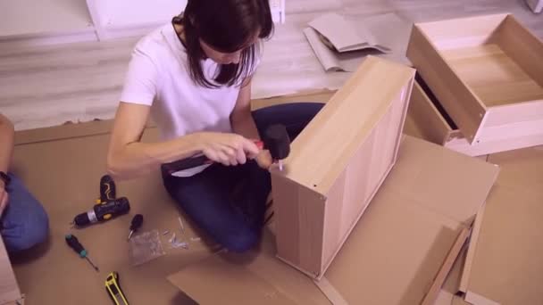 100万人の女性がリビングルームで自己組立木製の家具をまとめるDiyをしています — ストック動画