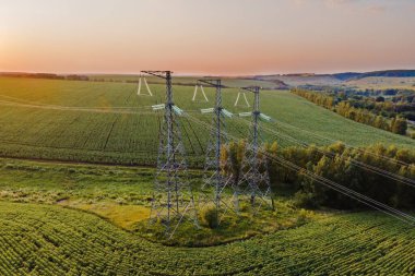 Gün batımında güç hattı iletim kulesi. Elektrik direği ve kablo kablolu yüksek gerilim şebekesi kulesi