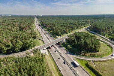 Araba trafiği kavşakta yol üzerinde kırsal ormanda, hava manzaralı.