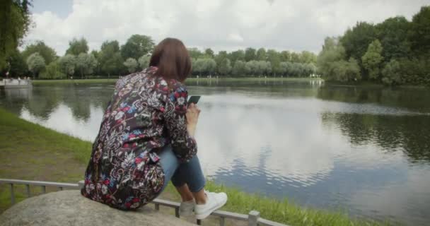 밀레니엄 스마트폰을 사용하여 공원의 네트워크에 호수를 이용하는 — 비디오