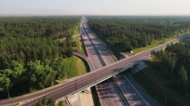 Otoyol ve üstgeçit, arabalar ve kamyonlarla dolu. Yol kavşağı şehrin dışında iki katlı bir kavşak. Yukarıda hava görünümü.