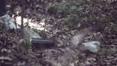 Bir çöp torbasının içinden gönüllü olarak park manzarası temizliyor. Ormanda çöp toplayan bir kadın. Çevre ve plastik atıkları