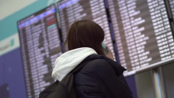 Frau Auf Dem Internationalen Flughafen Der Nähe Der Fluginformationstafel Reisende — Stockvideo