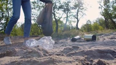 Gönüllü kadın çöp torbasında çöp topluyor. Çöpsüz gezegen konsepti. Doğa temizliği, gönüllü ekoloji yeşil kavramı. Çevre plastik kirliliği. Doğayı düşün.
