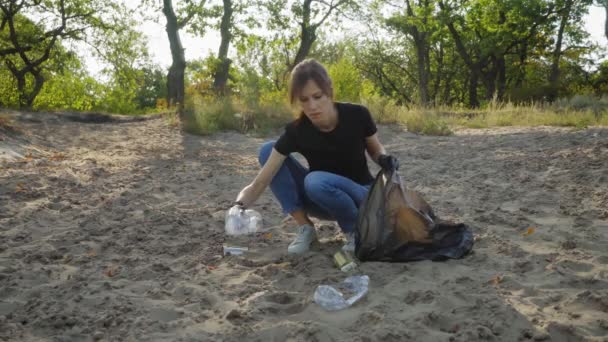 女志愿者在森林里的垃圾袋里收集垃圾 环境和塑料废物 — 图库视频影像