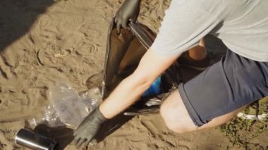 Gönüllü adam çöp torbasında çöp topluyor. Çöpsüz gezegen konsepti. Doğa temizliği, gönüllü ekoloji yeşil kavramı.
