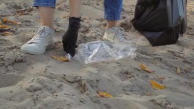 Kadın çöp torbasında plastik çöp topluyor. Çöpsüz gezegen konsepti. Doğa temizliği, gönüllü ekoloji yeşil kavramı