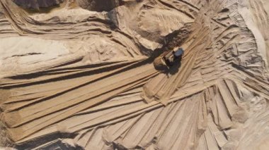 Buldozer kumlu bir taş ocağında kum kazıyor. Ağır makinelerle kum ocağı çalışma sürecinde