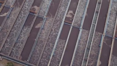 Lağım arıtma tesisi. Kirli lağım suyu ve hava manzarasını geri dönüştürmek için yuvarlak berraklaştırıcıları olan atık su arıtma tesisi