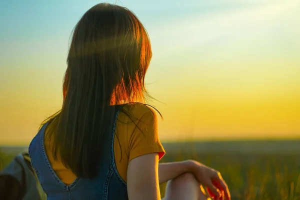 Millennial Woman relaxing at nature in summer at sunset