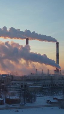 Çevresel çevre kirliliği sorunu şehirlerde. Dikey video. Tüten sanayi bölgesi bacaları..