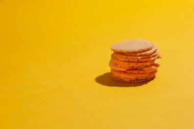 Domatesli buğday unundan yapılmış sağlıklı sebze cipsleri, kopyalanmış sarı arka planda mayasız.