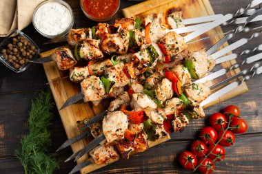 Hindi veya tavuk şiş kebap, biber domatesli metal şiş ve ahşap masa zemininde soğan.