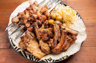 Ahşap arka planda pide soslu kuzu kaburgası.,