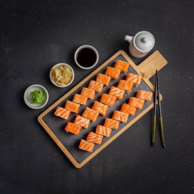 Philadelphia 'da klasik Dark Stone var. Somon, Philadelphia peyniri, salatalık, avokado. Japon suşisi. Üst görünüm, alanı kopyala