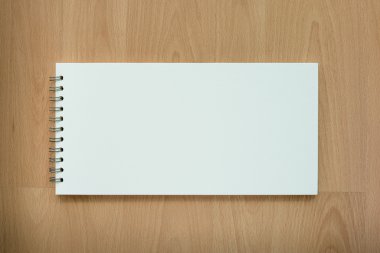Boş beyaz defter ve kalem ahşap arka plan üzerine açık