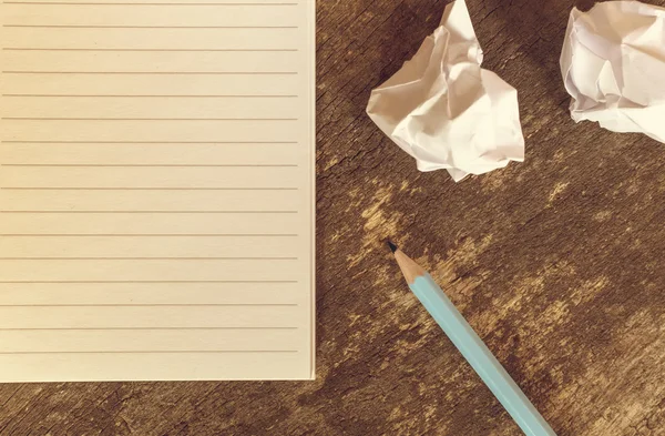 Top view of pencil notepad and crumpled paper on wooden table. — Stock Photo, Image