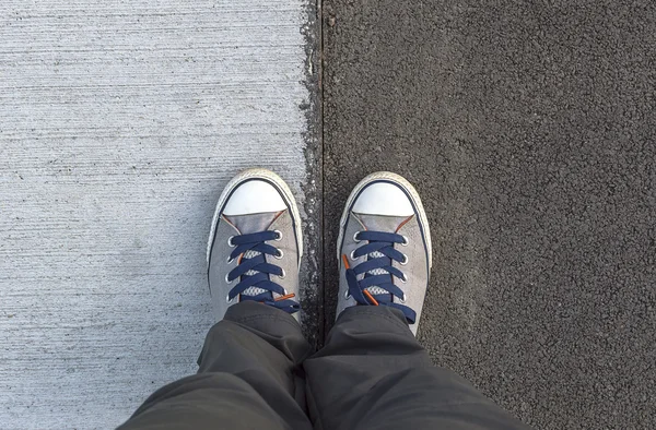 Turnschuhe von oben auf einer Straße. — Stockfoto