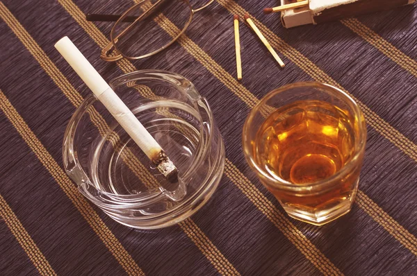 Whisky i papierosa w popielniczce. — Zdjęcie stockowe