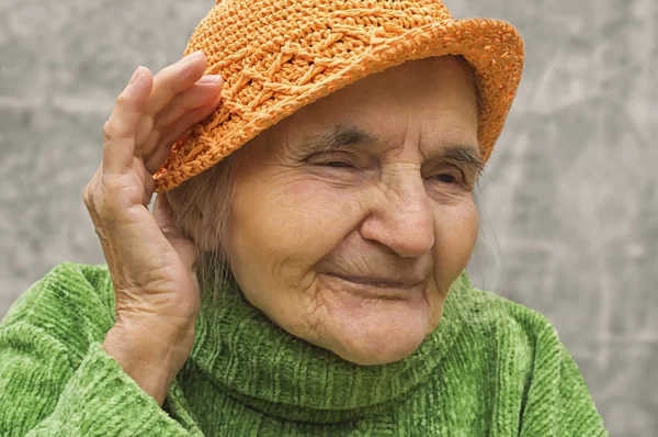 Ηλικιωμένη γυναίκα, κρατώντας το χέρι κοντά στο ένα αυτί. — Φωτογραφία Αρχείου
