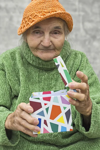 Elderly woman holding a gift — Stock Photo, Image