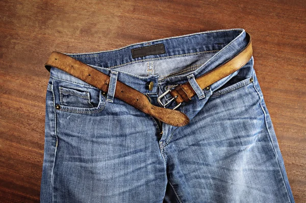 Blue jeans with leather belt.