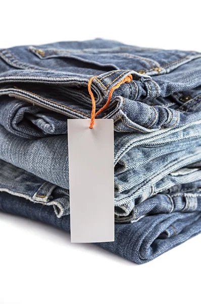 Pilha de jeans azuis com etiqueta . — Fotografia de Stock