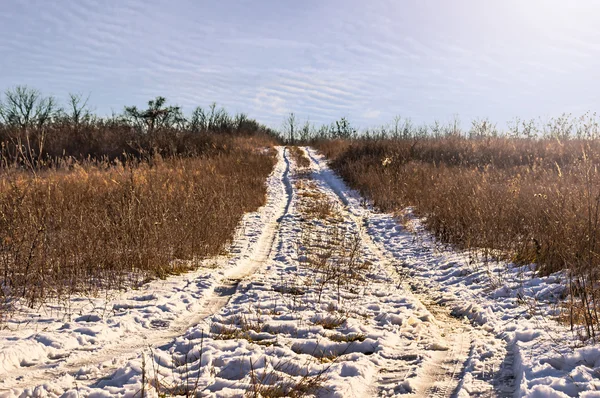 Pusta pokryta śniegiem droga w zimowym krajobrazie. — Zdjęcie stockowe