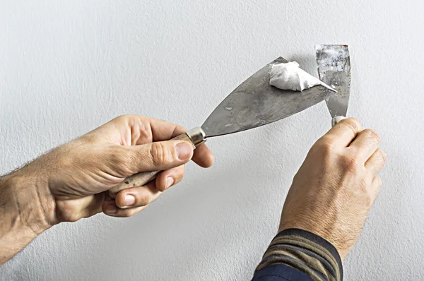 Werknemer met puttees mes werken bij het appartement muur vullen — Stockfoto