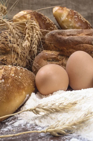 Stillleben mit rohen Eiern und frischem Knusperbrot. — Stockfoto