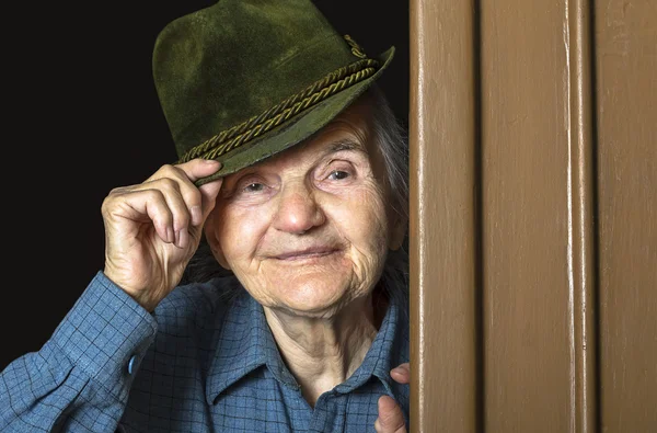 Oudere vrouw die lacht met een hoed in haar hoofd. — Stockfoto